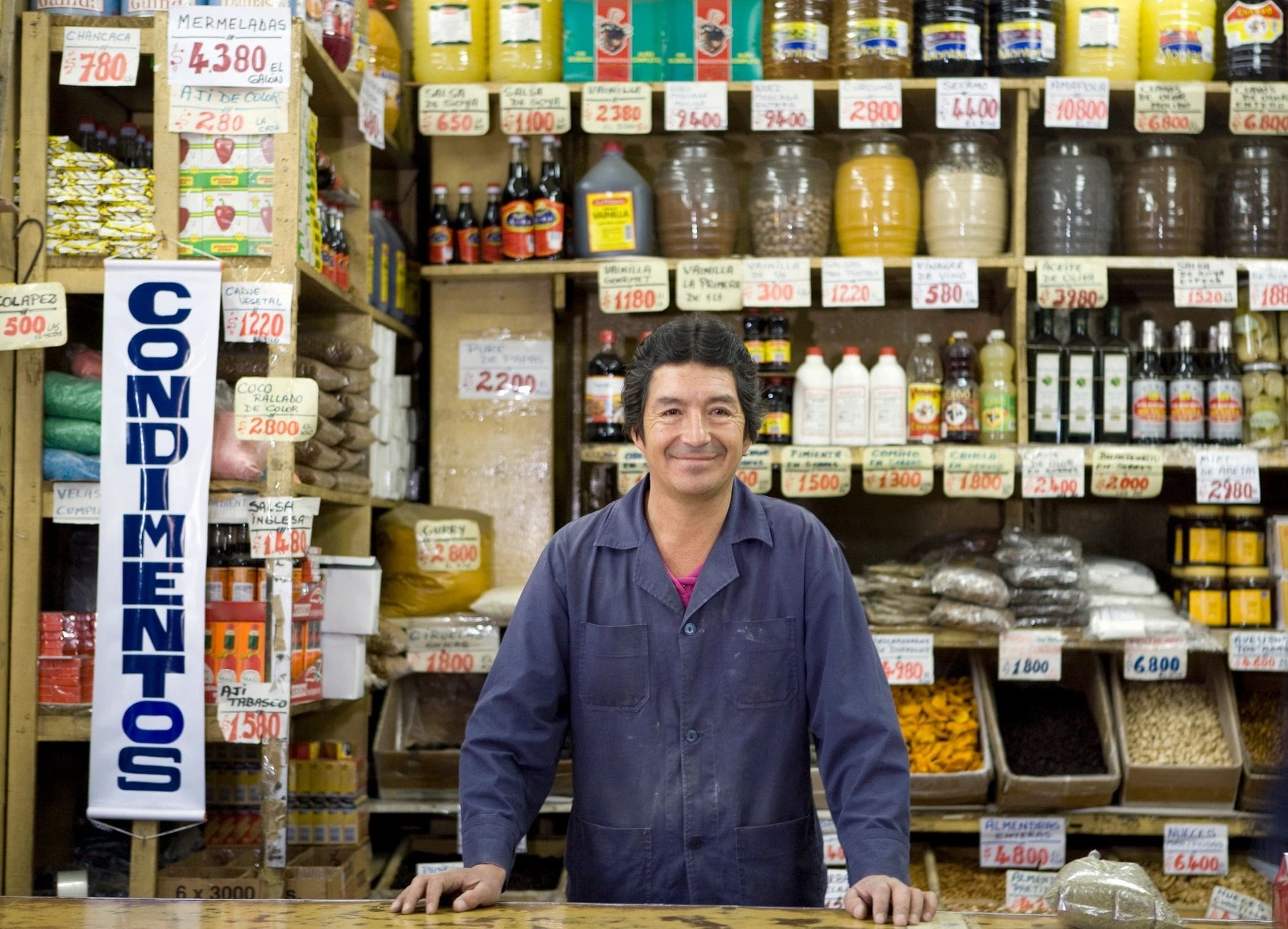 A man standing behind the counter of a store.